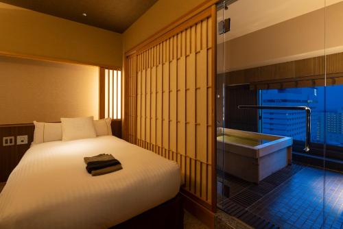 a bedroom with a bed and a bath tub at Kobe Bay Sheraton Hotel & Towers in Kobe