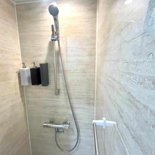 y baño con ducha con cabezal de ducha. en 湖北 寺の宿- GuestHouse去-来-現Ko-Rai-Gen en Nagahama