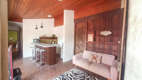 a living room with a couch and a kitchen at Rancho Relaxo in Tewantin