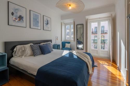 sypialnia z łóżkiem z niebieskim kocem w obiekcie Superb Apartments Overlooking Graça in Lisbon w Lizbonie