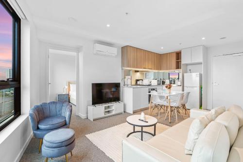 a living room with a couch and chairs and a kitchen at Southbank Stature Building2 Bedroom Apartment in Melbourne
