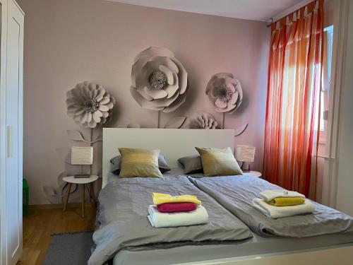 a bedroom with a bed with flowers on the wall at Fly Inn in Velika Gorica