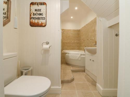 a bathroom with a toilet and a tub and a sink at Harbour Cottage in Ilfracombe
