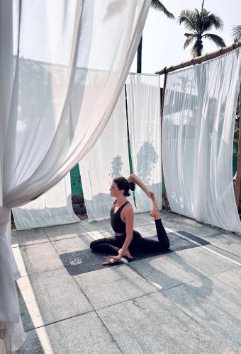 a woman sitting on the floor in front of a curtain at Vrindavan homestay in Munroe Island