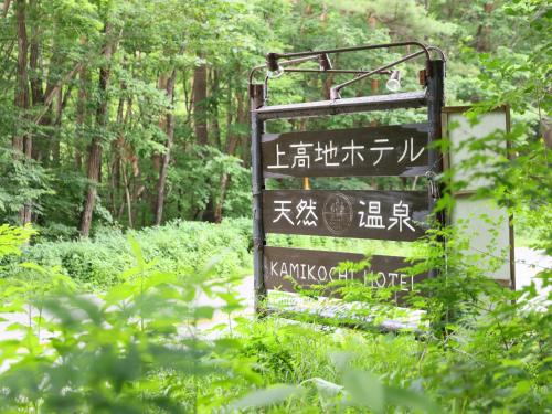 a sign in the middle of a forest at Kamikochi Hotel in Matsumoto