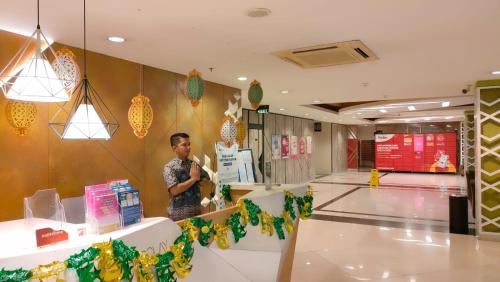 een man staat in een winkelcentrum bij Apartemen Grand Kamala Lagoon by Abel Stay Luxury in Pekayon Satu