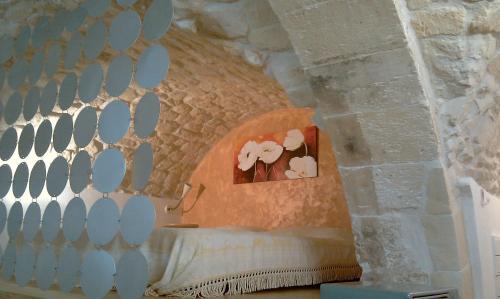 a bedroom with a bed in a stone wall at Dammuso Raffaello in Scicli