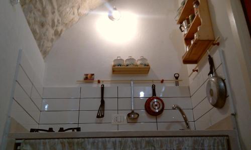 a kitchen with a shelf and some pots and pans at Dammuso Raffaello in Scicli