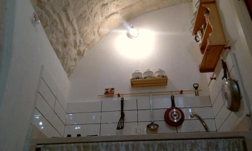 a kitchen with a ceiling with a shelf and utensils at Dammuso Raffaello in Scicli