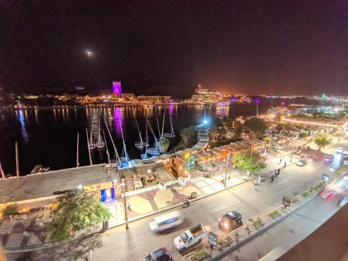 Blick auf eine Stadt in der Nacht mit Hafen in der Unterkunft TOP HOTEL in Assuan