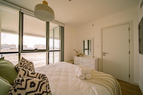 Raha Lofts Hosted By Voyage في أبوظبي: غرفة نوم عليها سرير وفوط