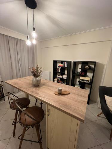 a kitchen with a wooden counter with two chairs at NIKI APARTMENT 80 m2 IN GRIBOVO in Nafpaktos