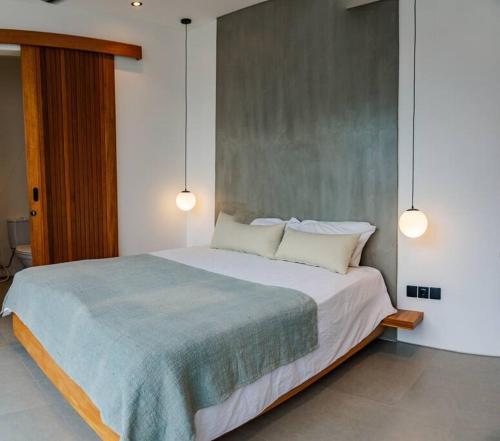 - une chambre dotée d'un grand lit avec deux lumières dans l'établissement Casa Mori in Pererenan, à Canggu