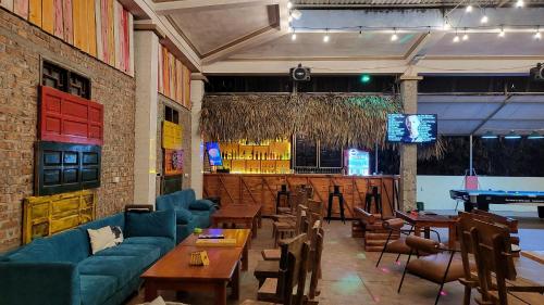 a restaurant with couches and tables and a bar at Ha Giang Loop Rabbit Hostel & Tours in Ha Giang
