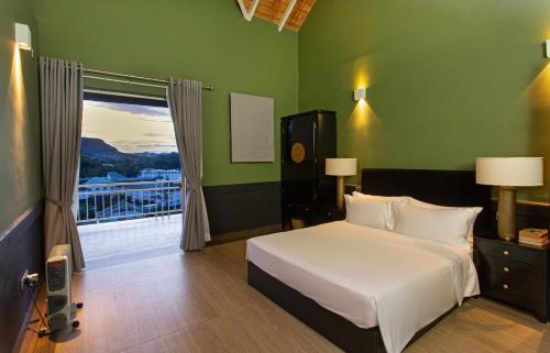 a bedroom with a white bed and a window at W15 Glenfall Nuwara Eliya in Nuwara Eliya