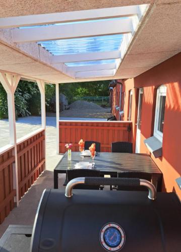 un patio con una mesa y un banco en una terraza en Idyllic Countryside Apartment en Christiansfeld