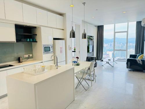 吉隆坡的住宿－The Faced Platinum KLCC，一间带白色橱柜的厨房和一间客厅