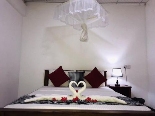 a bedroom with a bed with a heart decoration on it at Sigiriya Rock Star Home Stay in Sigiriya