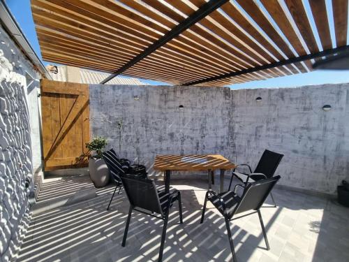 einen Tisch und Stühle auf einer Terrasse mit Holzdecke in der Unterkunft Vila Kyra in Rtina