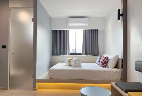 a bedroom with a bed and a window in it at Hatyai Midtown Hotel in Hat Yai