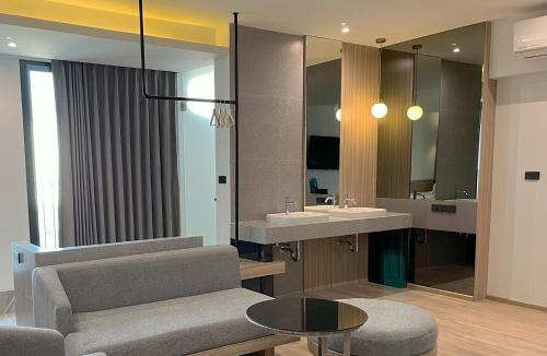 uma casa de banho com um lavatório, uma cadeira e um espelho. em Hatyai Midtown Hotel em Hat Yai