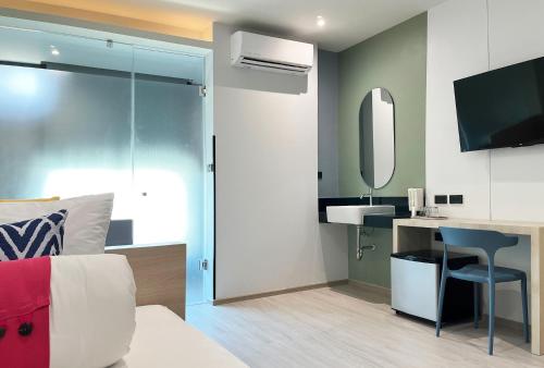 a bedroom with a bed and a desk with a mirror at Hatyai Midtown Hotel in Hat Yai