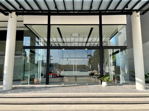 a glass facade of a building with columns at Hatyai Midtown Hotel in Hat Yai