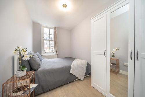 a white bedroom with a bed and a window at Charming 2 Bedroom Flat in Central London in London