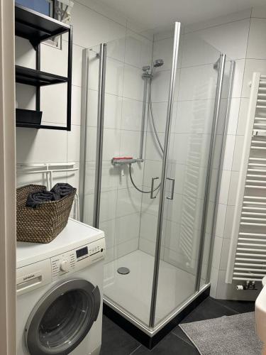 een badkamer met een douche en een wasmachine bij AMAROOM apartments 2 in Karlsruhe