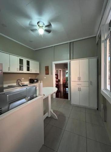 una cucina con armadi bianchi e un ventilatore a soffitto di La Compañía a Golfito