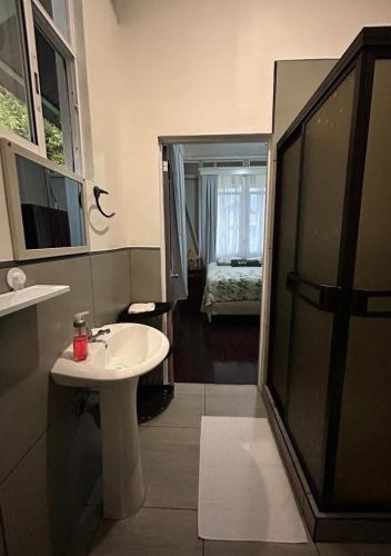 a bathroom with a sink and a shower with a window at La Compañía in Golfito
