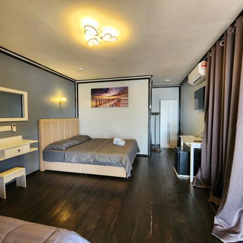 a bedroom with a bed and a desk and a television at Permai Chalet Tioman in Kampong Juara