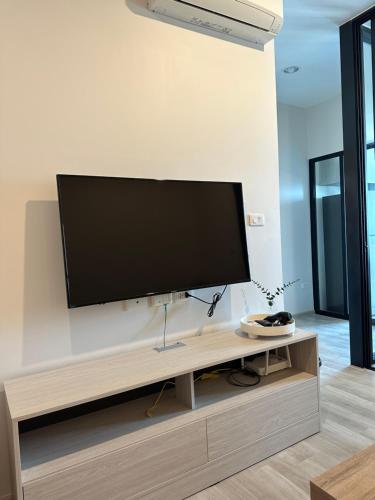 a flat screen tv on a wall in a living room at Private 1 Bedroom at Niche Mono Mega Space Bangna in Bangna