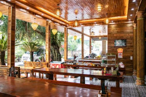 an empty restaurant with wooden tables and benches at Cao Thạch Homestay in Ninh Binh