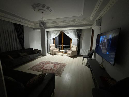 a living room with a couch and a flat screen tv at Seafront Apartment Rize-Ardeşen in Ardeşen