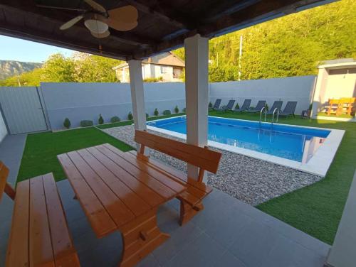 a patio with a bench and a swimming pool at Sasha Apartment and Swimming Pool in Gornje Selo