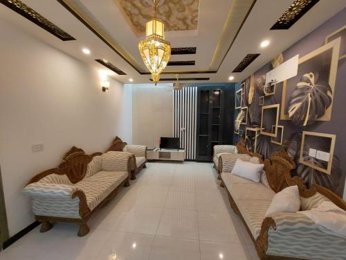 - un salon avec plusieurs canapés et une télévision dans l'établissement IVY Guest House II, à Islamabad