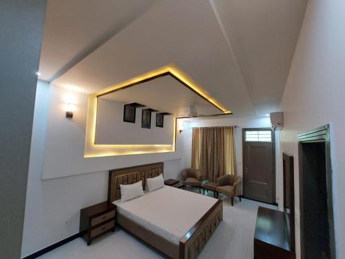 - une chambre avec un lit et un miroir mural dans l'établissement IVY Guest House II, à Islamabad