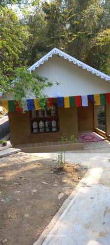 a small building with a colorful banner on it at Tenam Garden homestay in Kalimpong