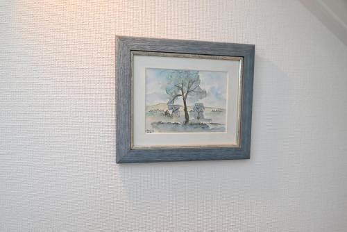 a framed painting of a tree on a wall at Sincfal 10 Cadzand in Cadzand-Bad