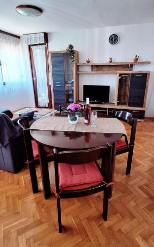 ein Wohnzimmer mit einem Holztisch und Stühlen in der Unterkunft Apartment V&S in Pula