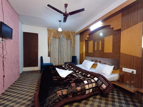een hotelkamer met 2 bedden en een plafondventilator bij HOTEL NEW AASHIYANA in Srinagar