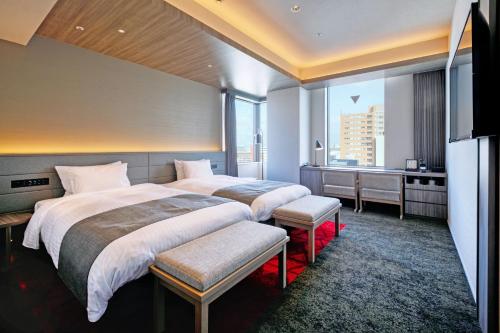 a hotel room with two beds and a window at Hotel JAL City Fukuoka Tenjin in Fukuoka