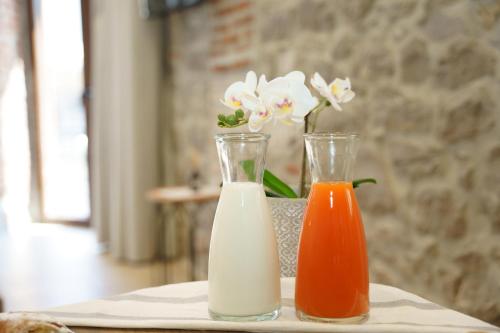 two bottles of milk and a vase of flowers on a table at MONOPATI HOUSE in Mouzákion