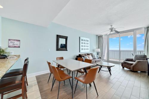 Un comedor y una sala de estar con mesa y sillas. en Lighthouse 1512, en Gulf Shores