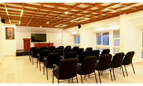 a room with chairs and a podium and a screen at Carmel Top Munnar in Munnar