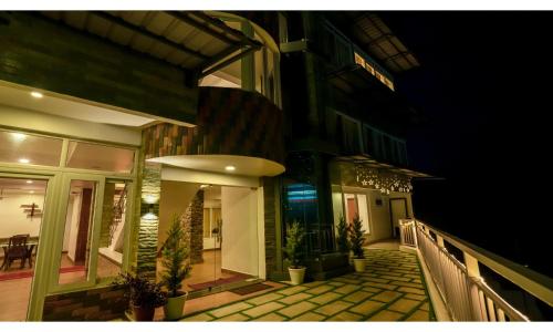 a balcony of a building with plants on it at night at Carmel Top Munnar in Munnar
