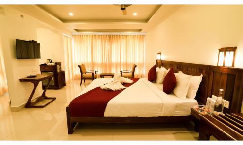 a hotel room with a large bed and a desk at Carmel Top Munnar in Munnar