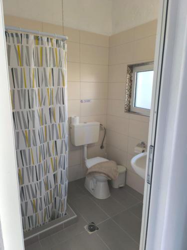 a bathroom with a toilet and a shower curtain at Falirakion Beach Studios in Faliraki