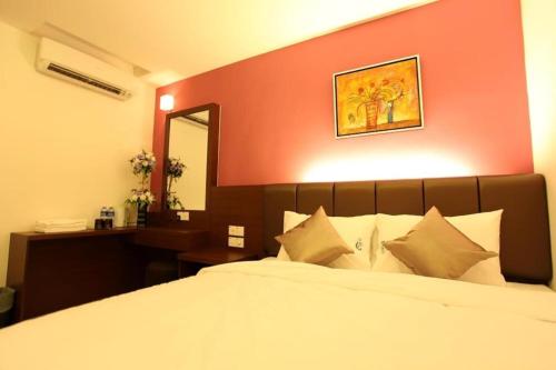 a bedroom with a large bed with a red wall at AVARIA SIGNATURE in Melaka